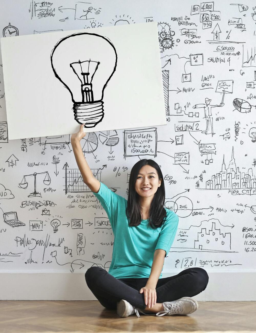 woman draw a light bulb in white board