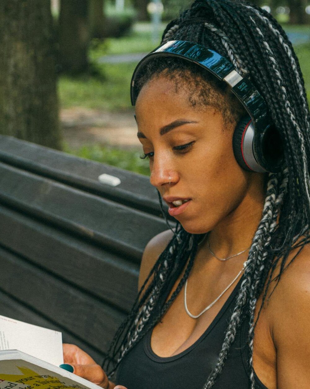 a woman reading a book in the park