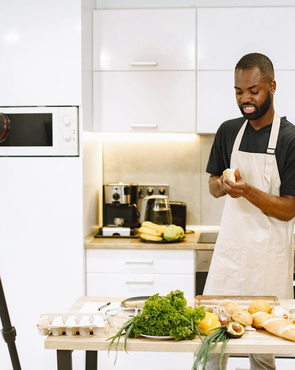 male vlogger in white apron slicing a bread
