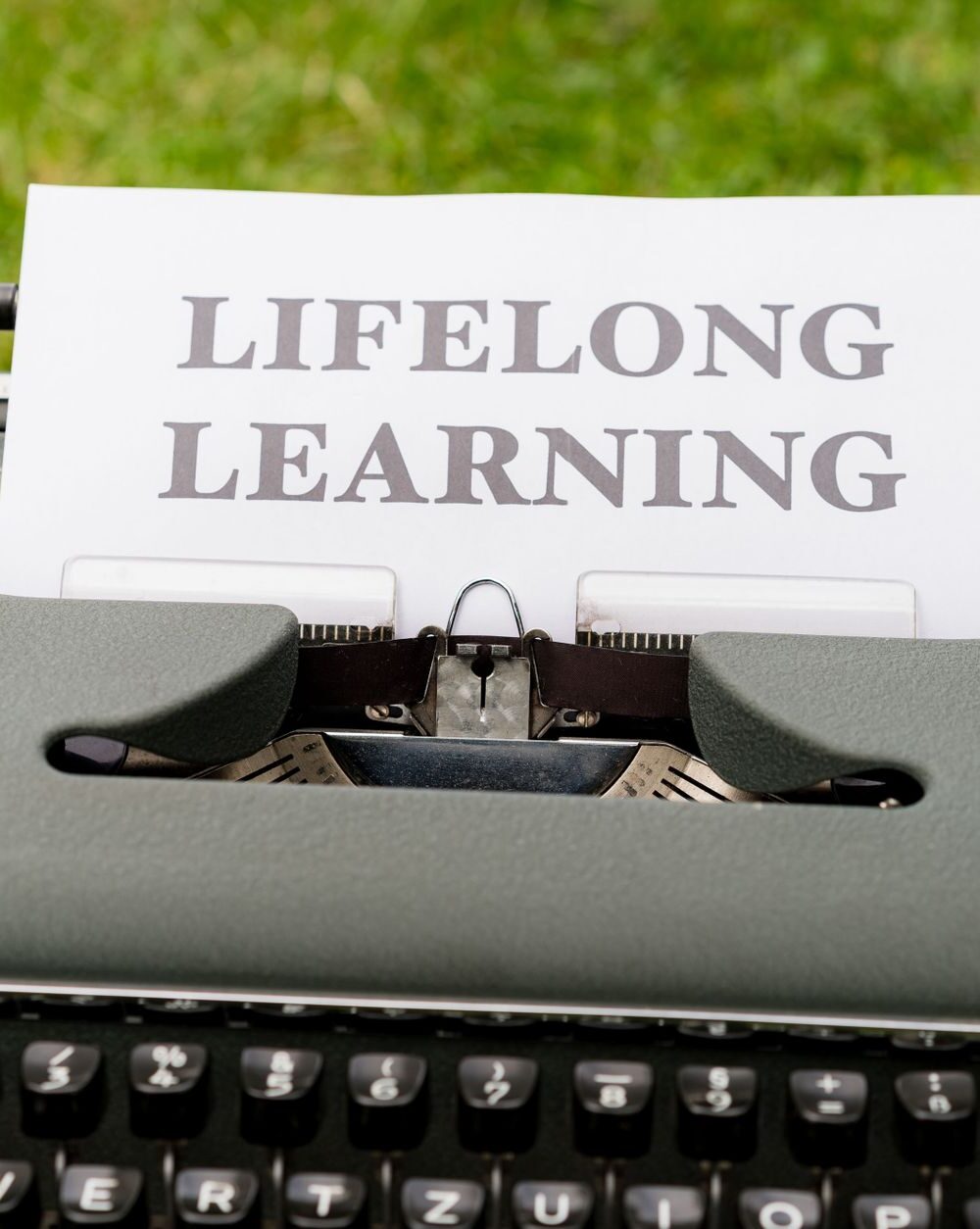 a typewriter with a paper that says life long learning
