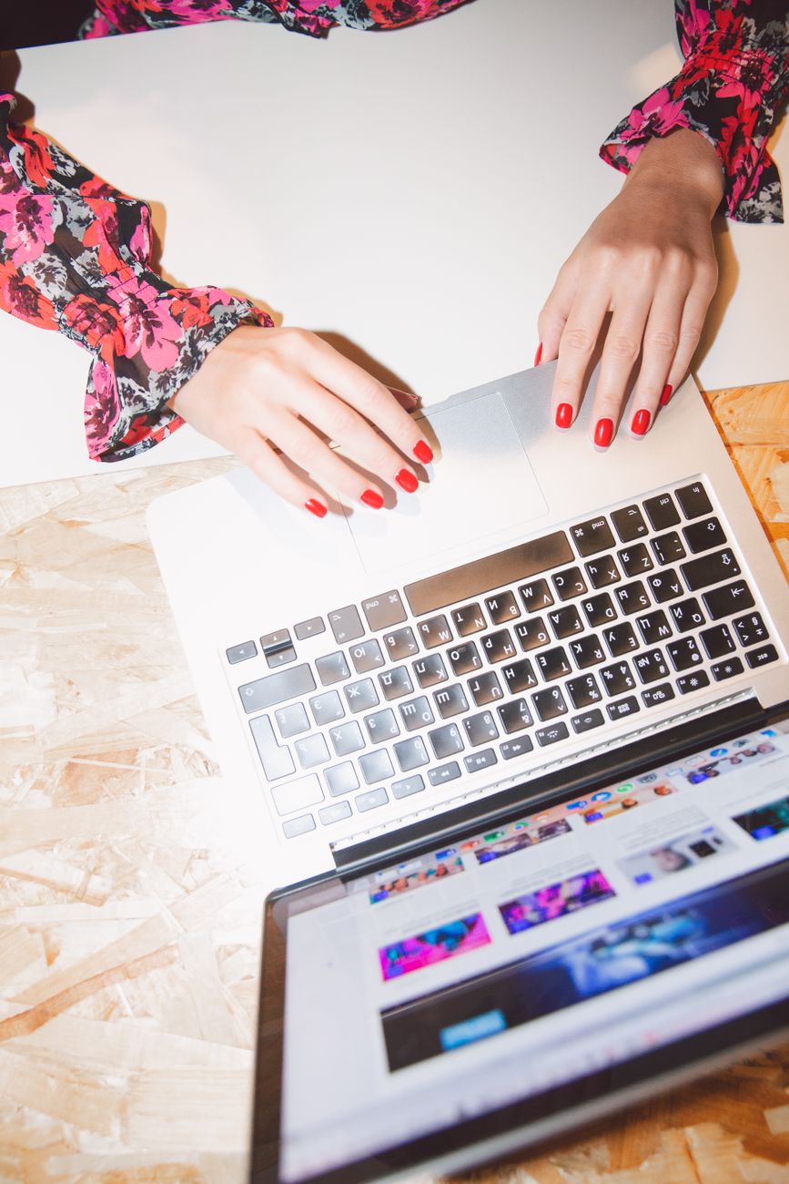 person using macbook pro on white table