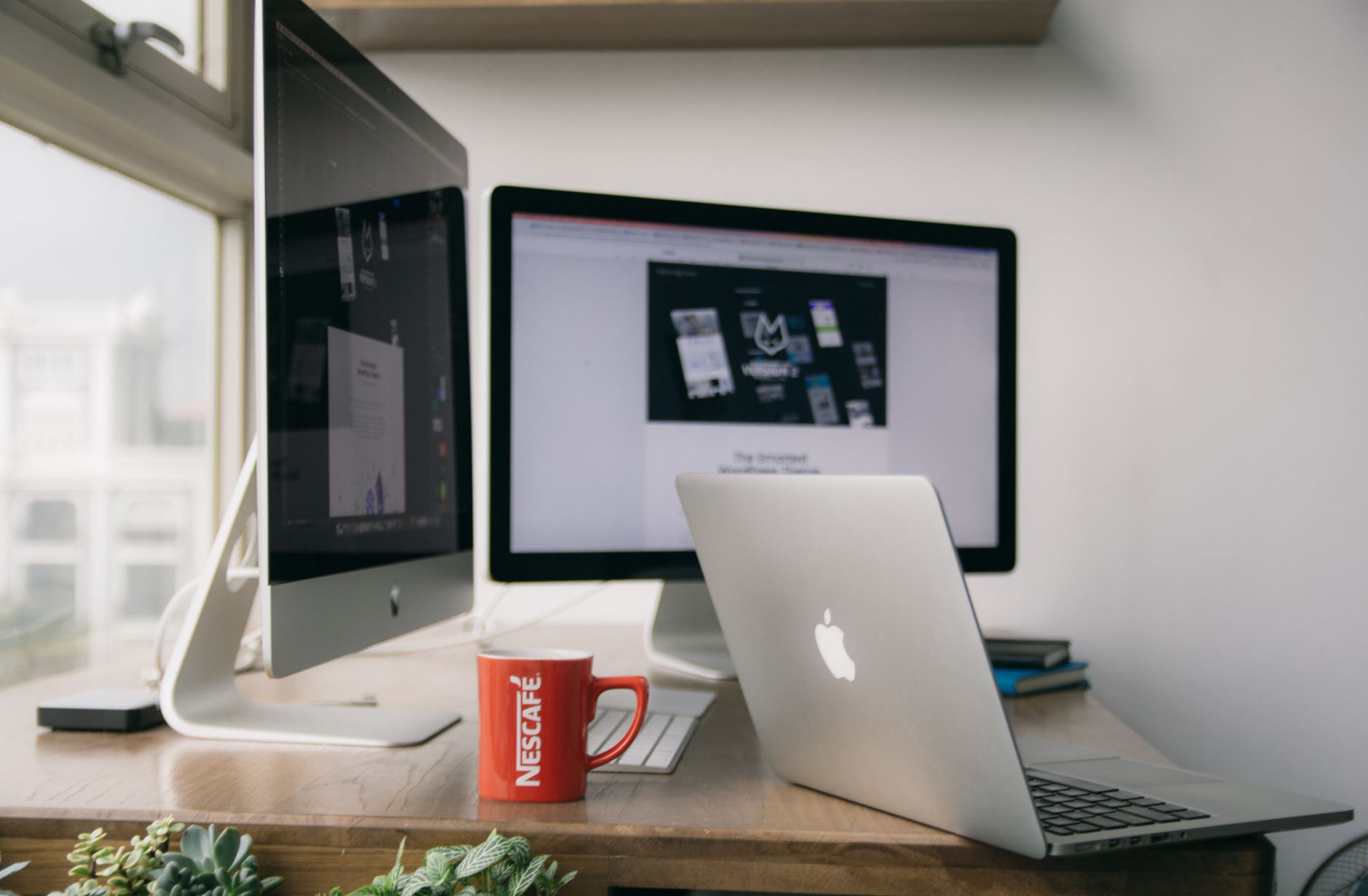 silver macbook on top of brown wooden table